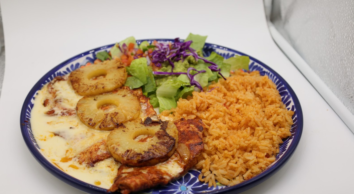 Grilled chicken covered with cheese sauce, pineapple slices, served with rice and salad