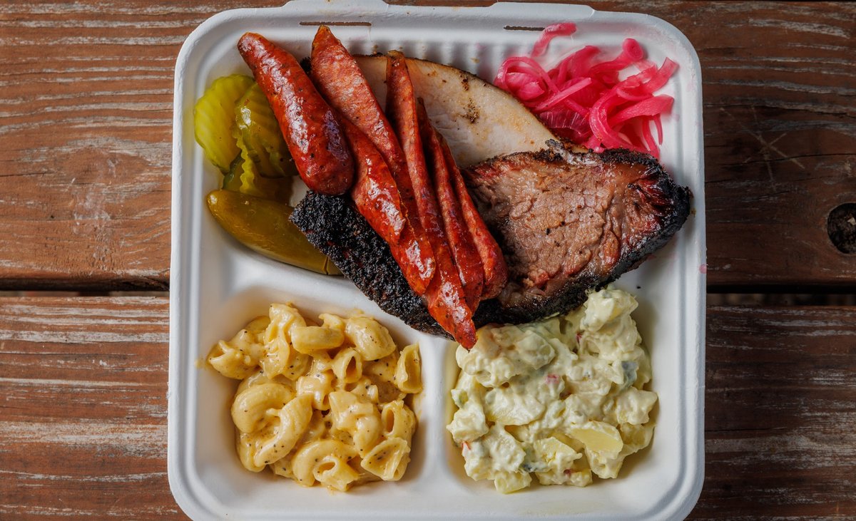 Brisket, macaroni and cheese, and potato salad in a plastic container