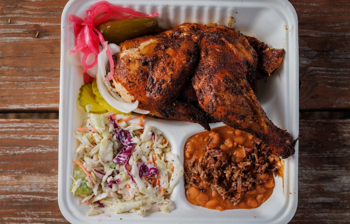 A tray with a chicken, salad and beans