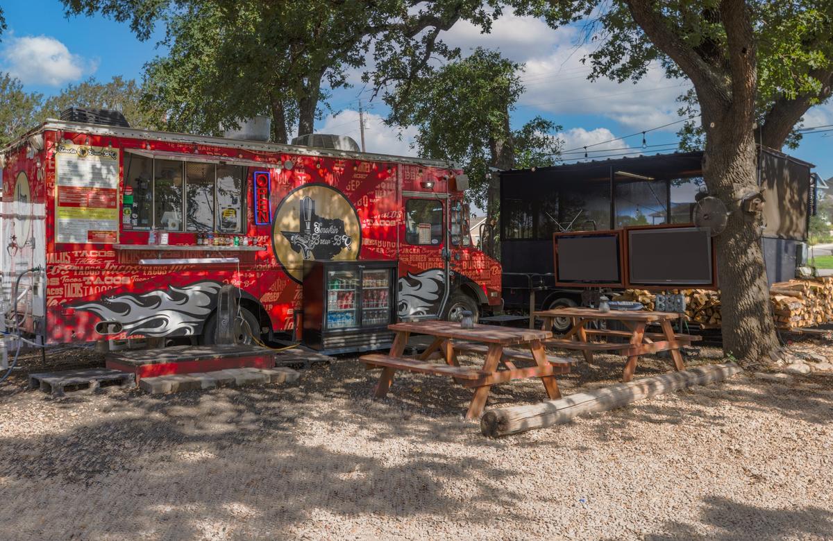 A food truck parked in a dirt lot