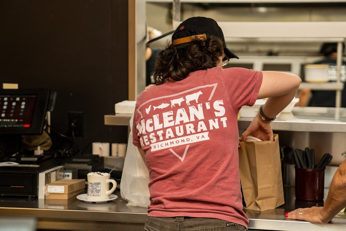 Back view of a staff member in action behind a counter