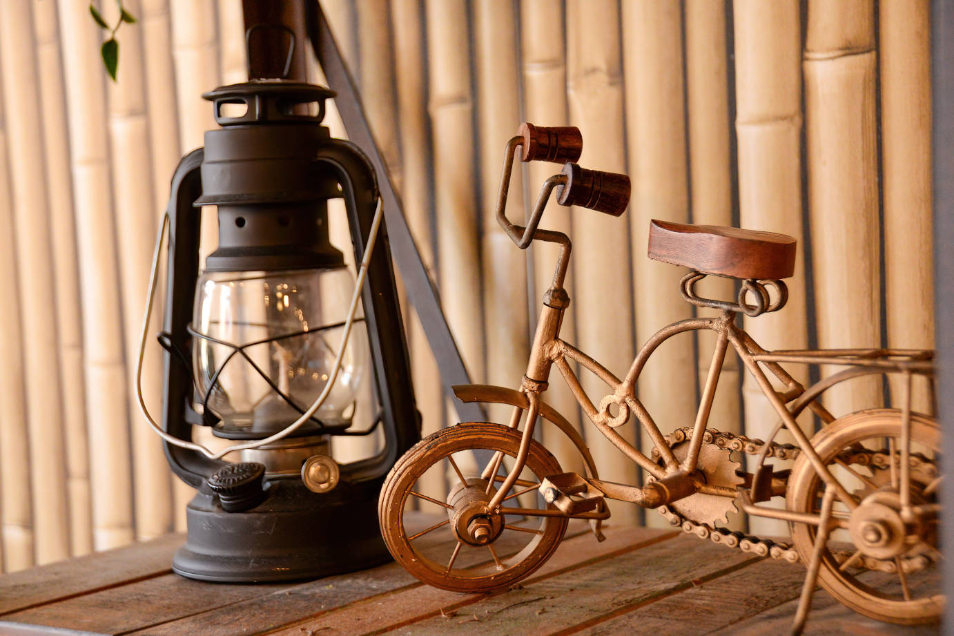 Wooden toy bike and oil lamp on table