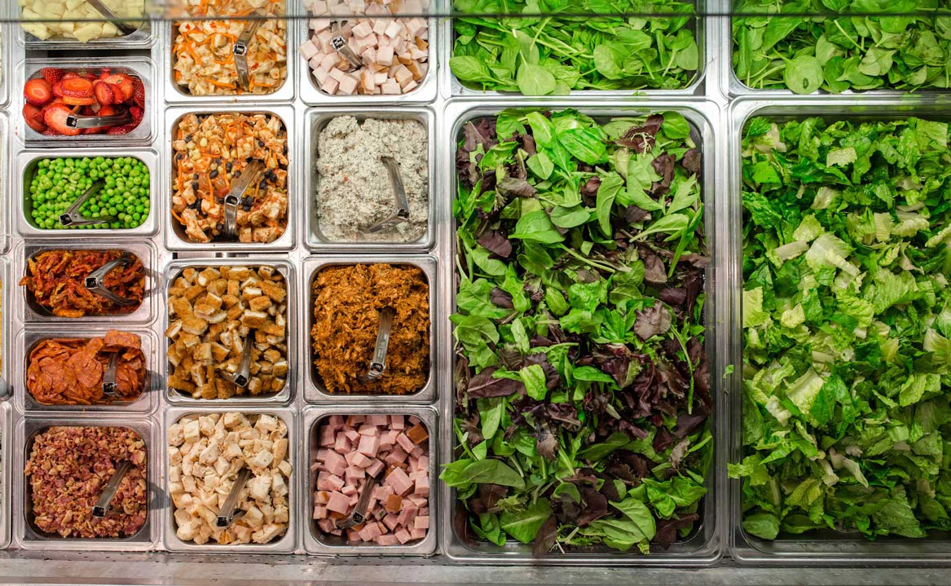 Salad bar compartments with different salad items, overhead view