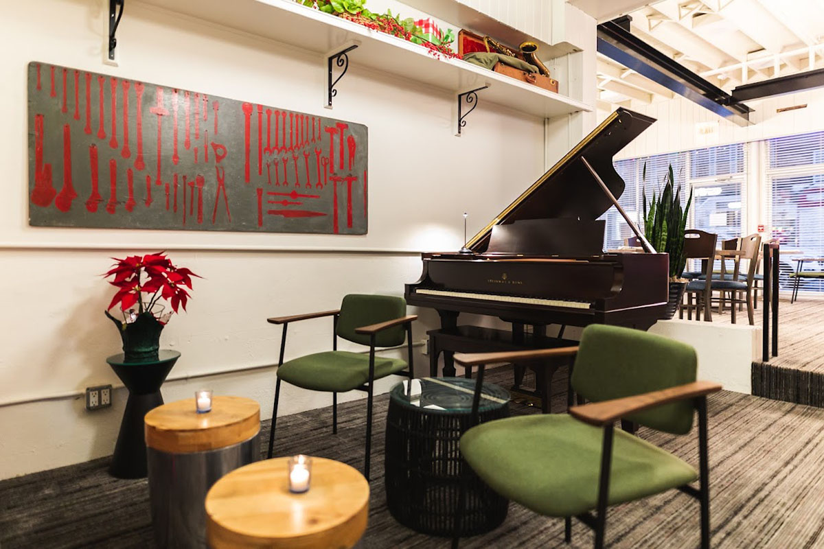 Small seating area with a decorative plant pot, coffee tables, and a piano