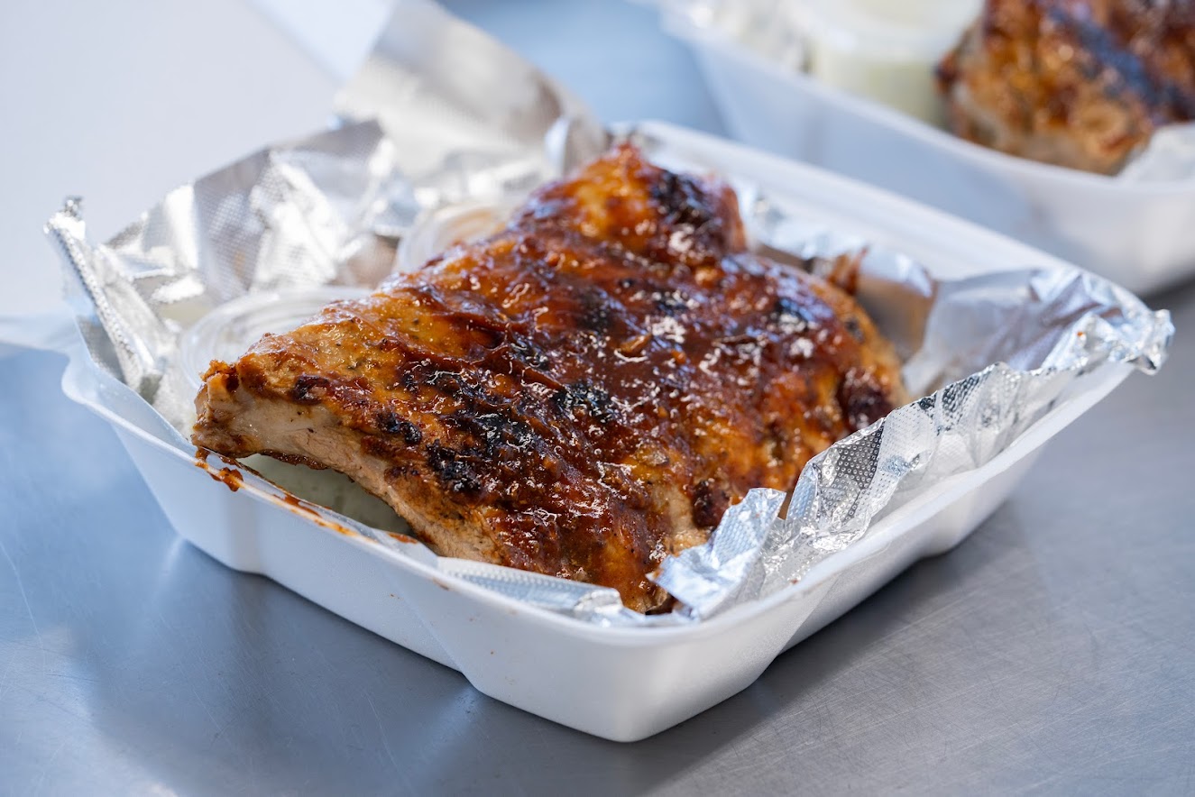 Ribs being placed into takeout container 