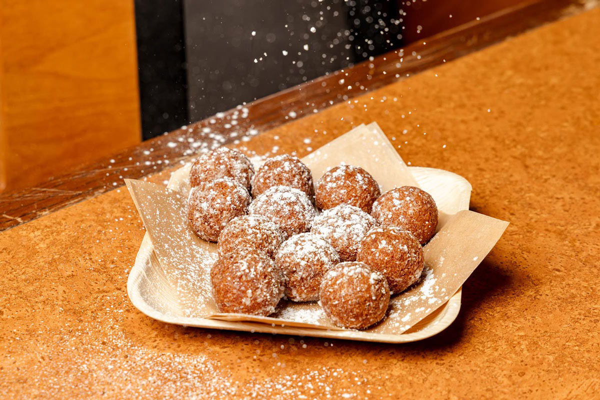 Deep fried donuts sprinkled with powdered sugar