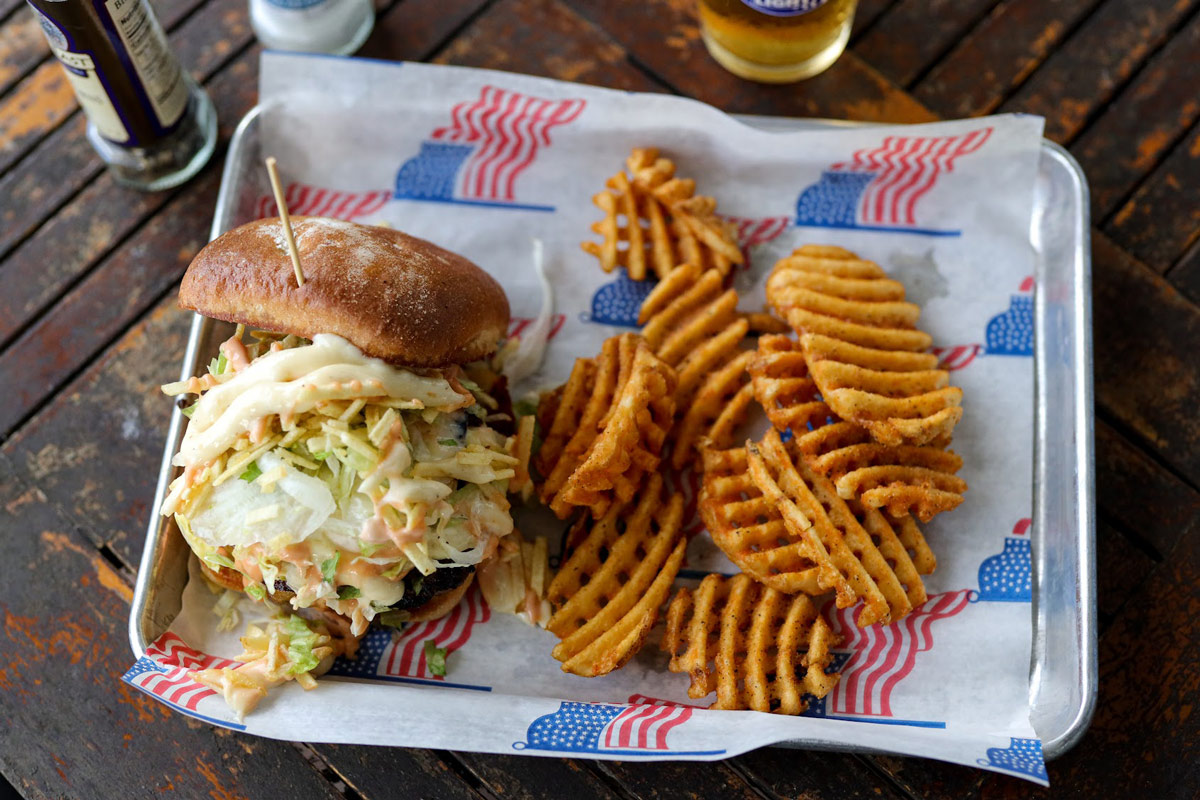 Burger with slaw and fries, accompanied with beer