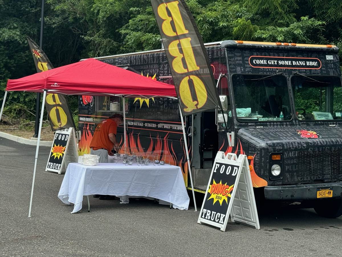 A set up Food Truck with a table and tent.