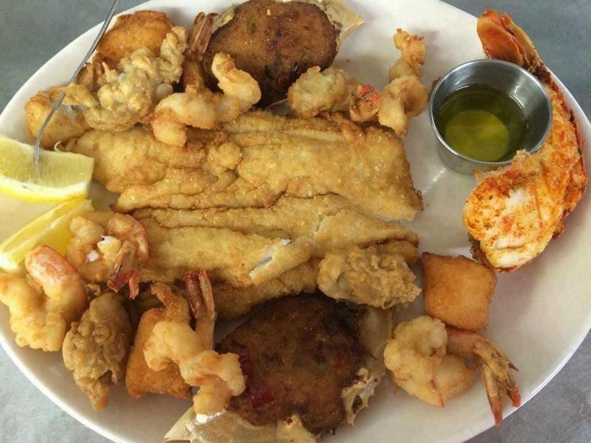 Crab cakes, fried fish and fried shrimp on platter 