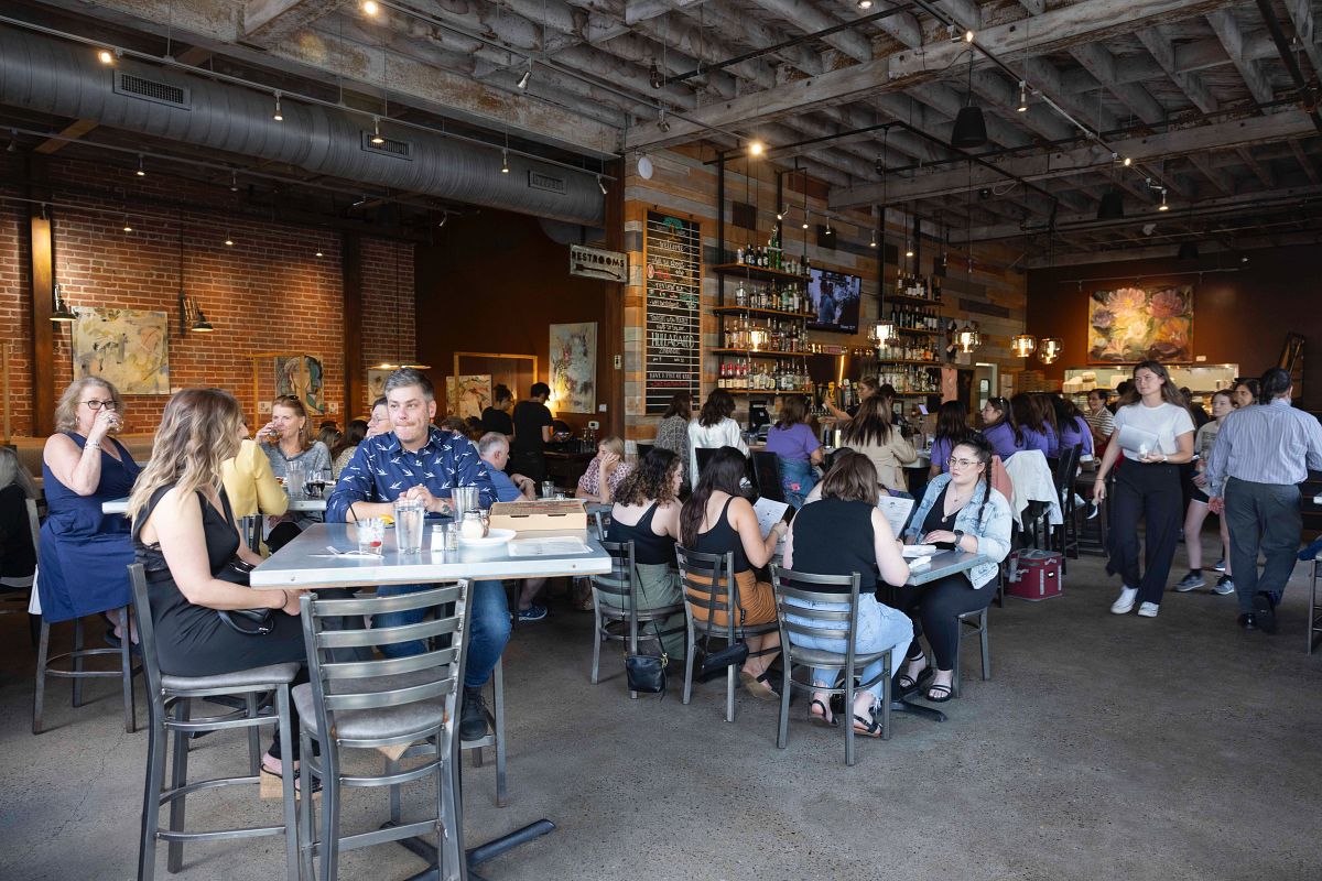 Indoor restaurant space with people sitting at high and low tables