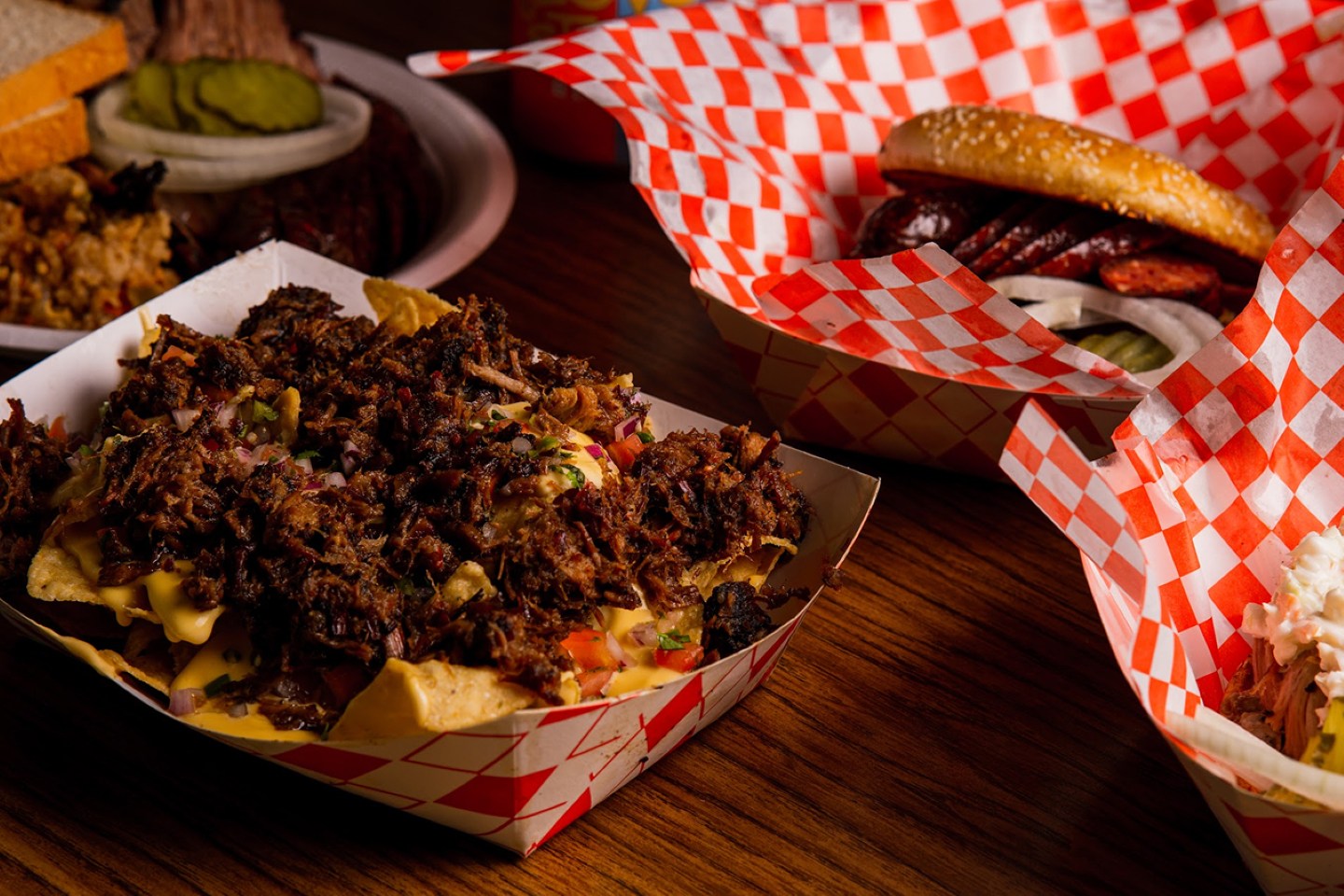 Brisket-loaded nachos, sausage sandwiches, and classic Texas BBQ plates served at Augie’s Barbed Wire Smokehouse in San Antonio.
