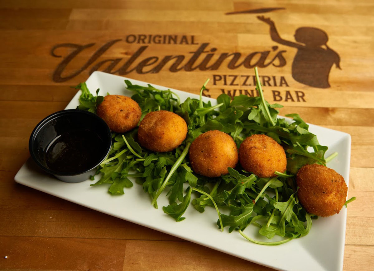 Fried goat cheese balls on a bed of arugula with a side of house made hot honey