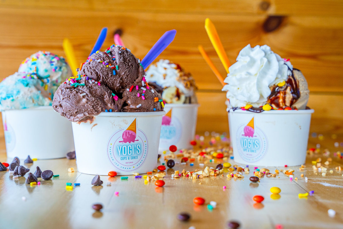 A group of ice cream cups with sprinkles and candy