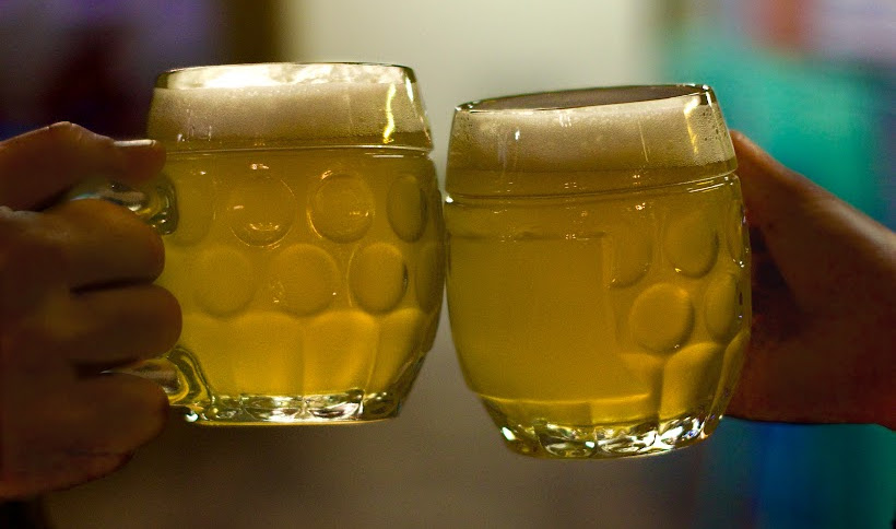 Two beer mugs clinking in a toast