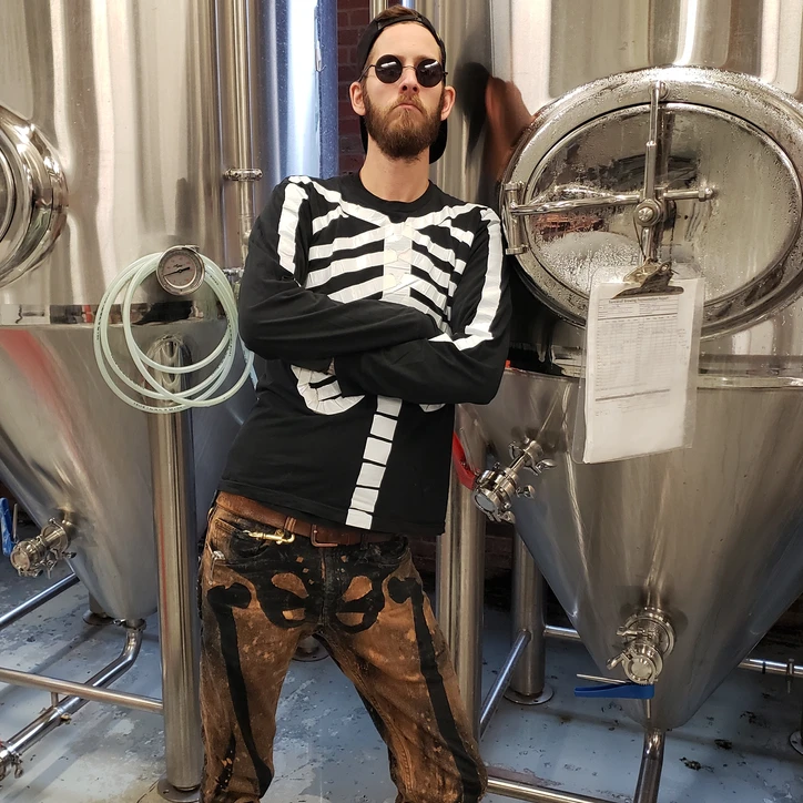 Stevie posing by brewery tanks