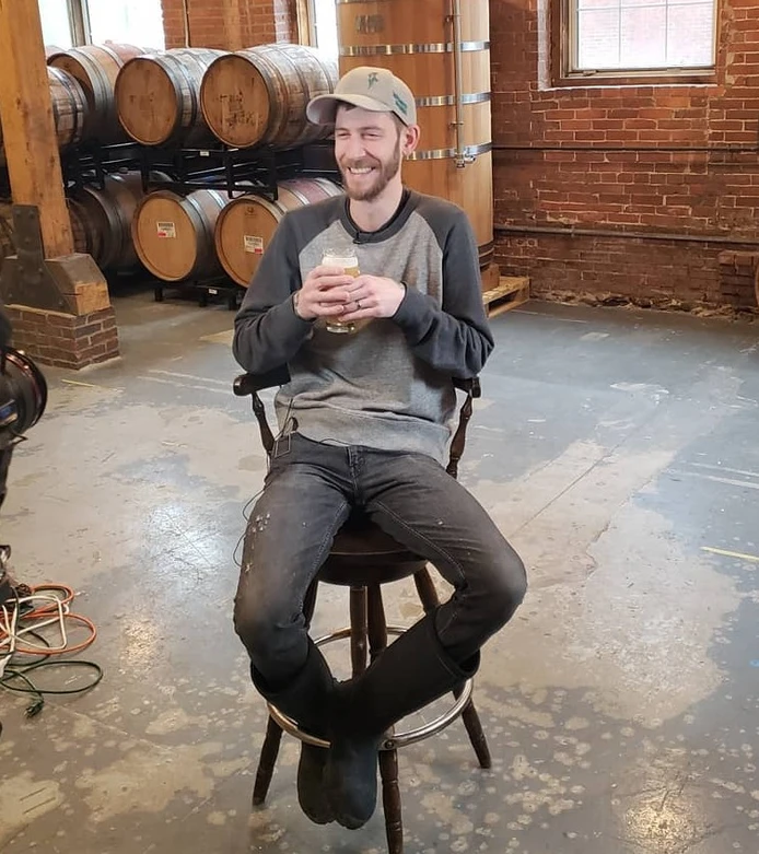 Stevie sitting down and having a beer  inside the brewery