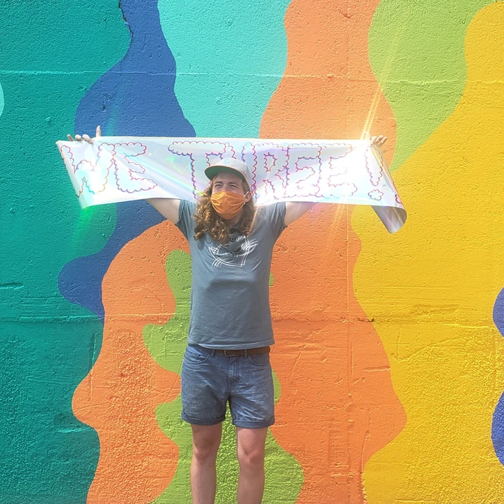 Wylie holding a banner in front of a colorful wall