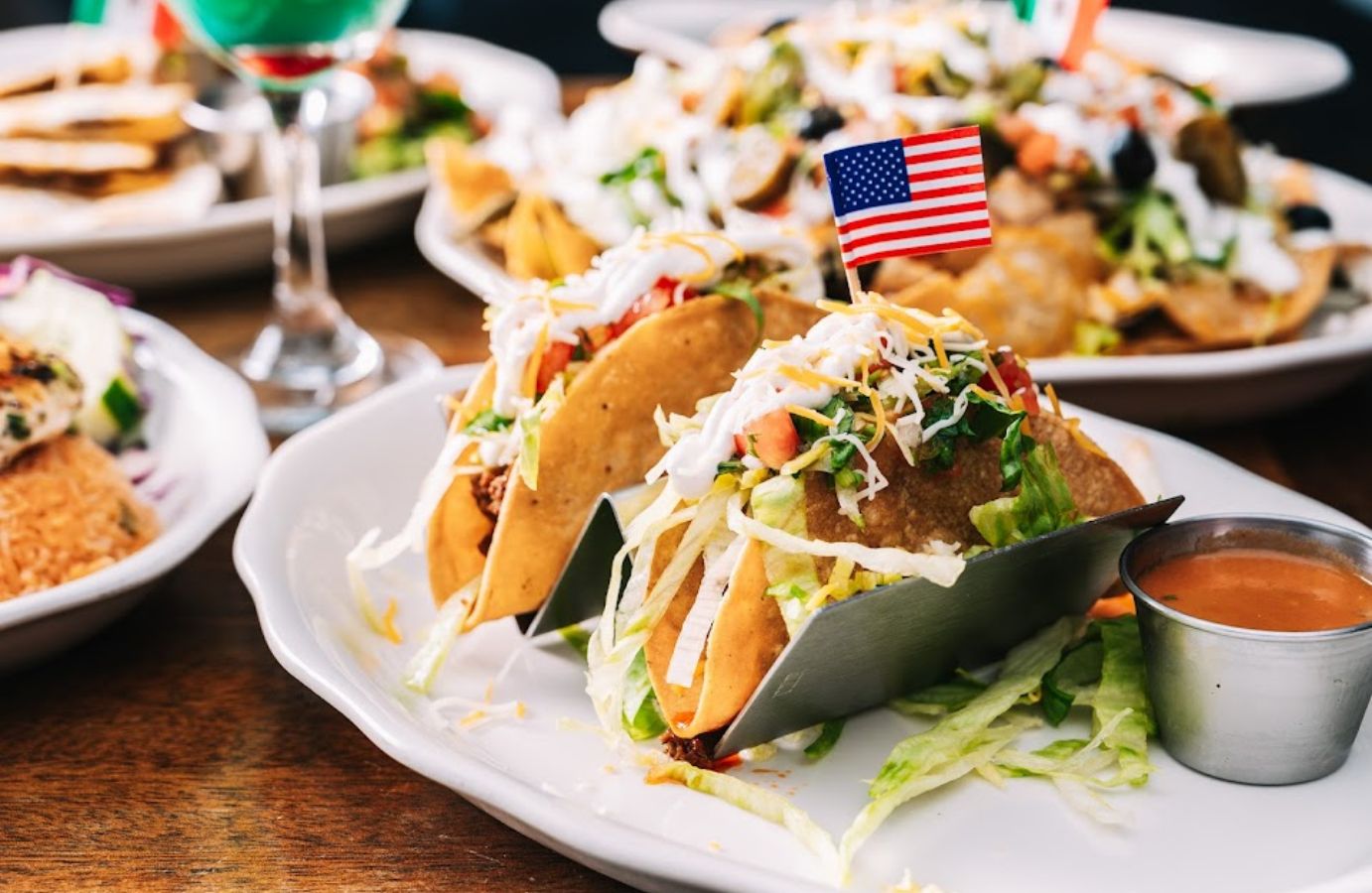 Closeup of a plate of tacos with a small American flag