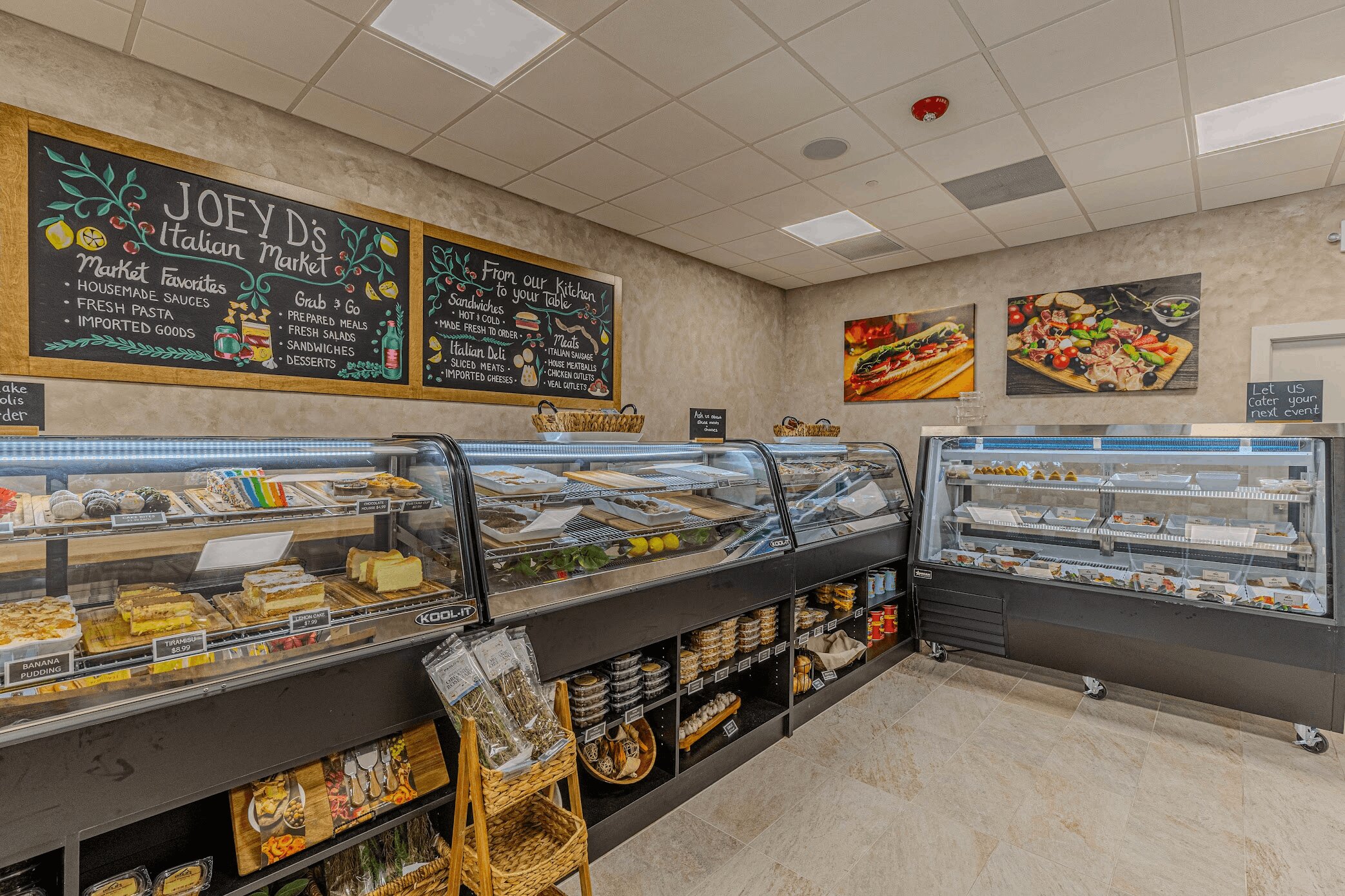 Deli counter with glass cases, chalkboard menu, and food photos on wall