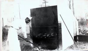 Herbert Portlock cooking hams on the outside barbecue pit