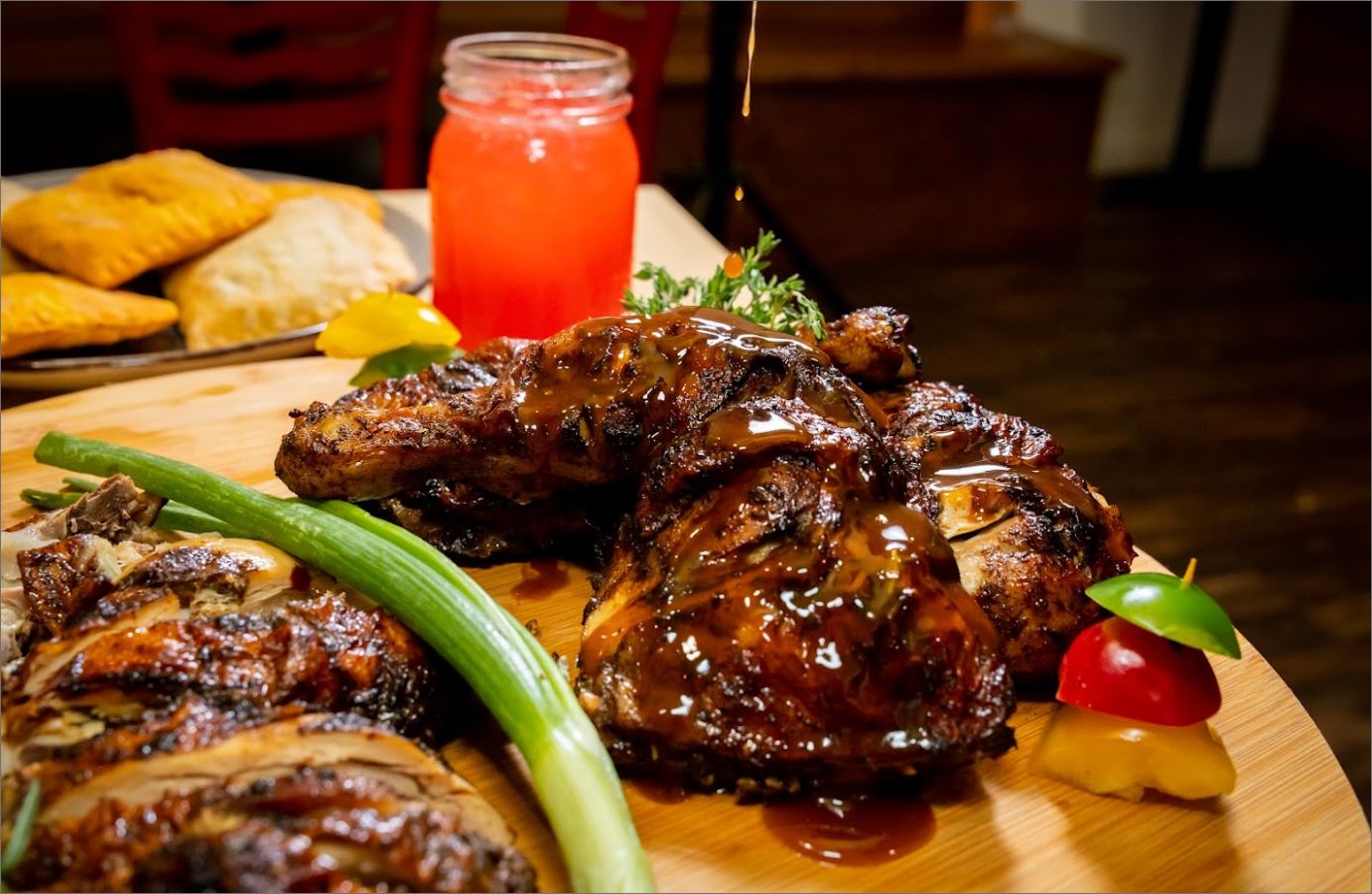 Jerk Chicken on a wooden board with fresh vegetables