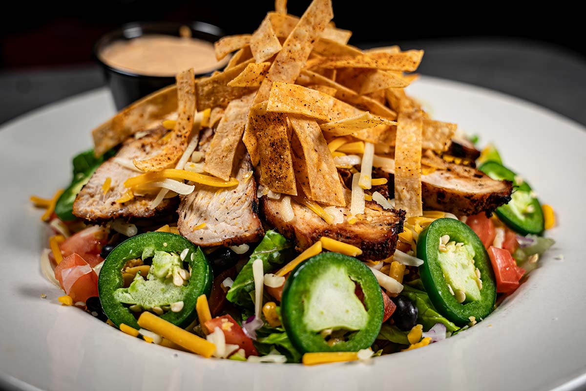 A plate of food featuring a delectable combination of chicken, peppers, and cheese.