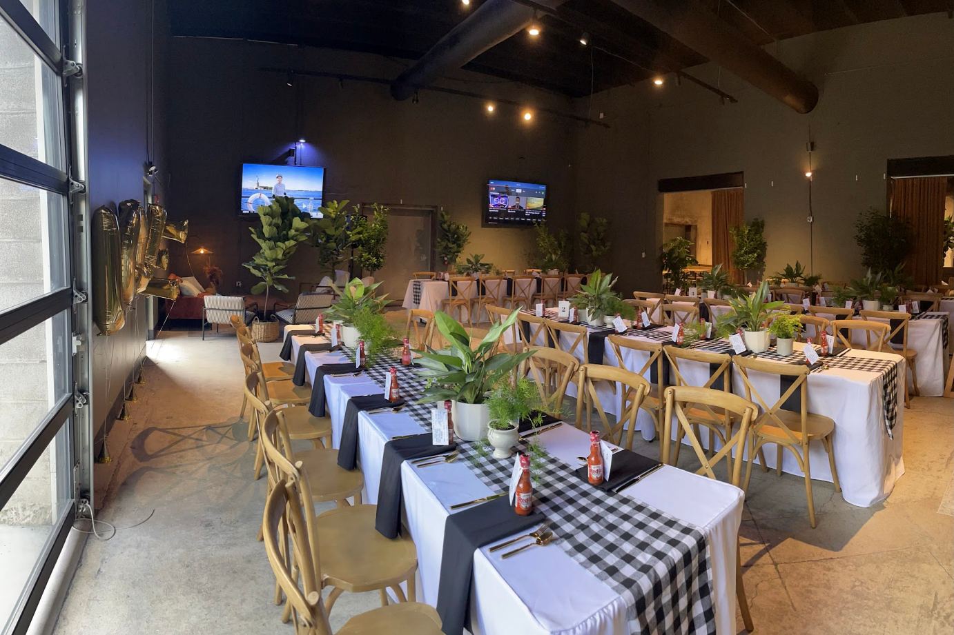 A spacious community room with tables and chairs arranged for a party atmosphere