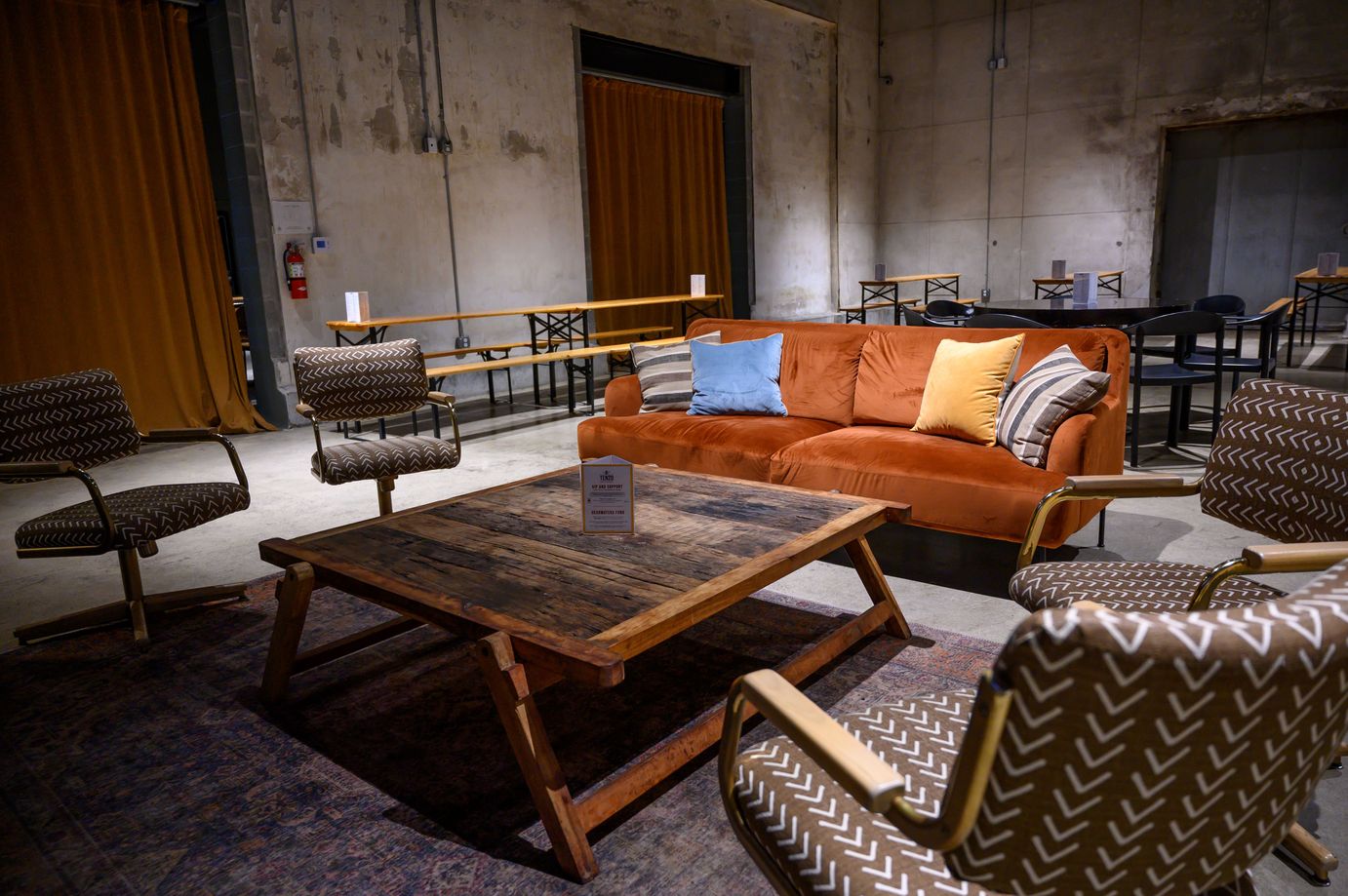 A cozy lounge room with orange furniture, and chairs for relaxation