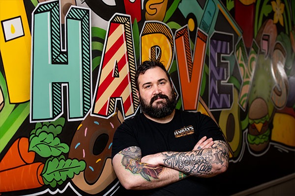 Chef Harvey poising in front of the grafitti wall