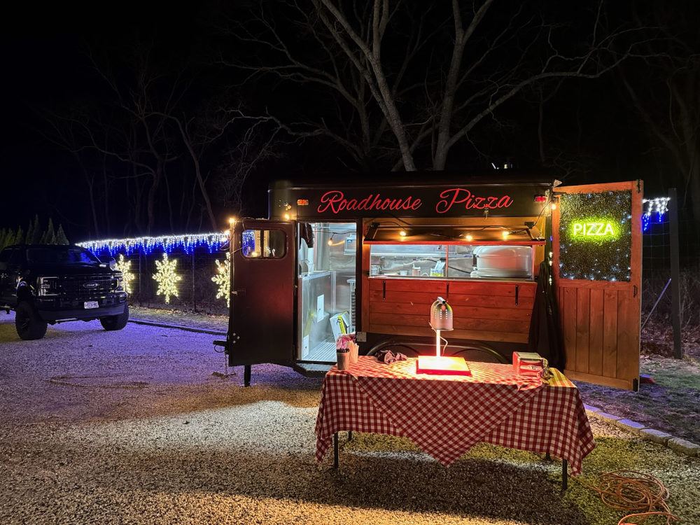 pizza truck with a table in front of it