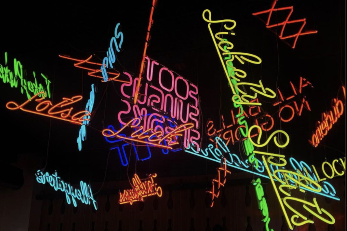 A group of neon signs hanging from the ceiling