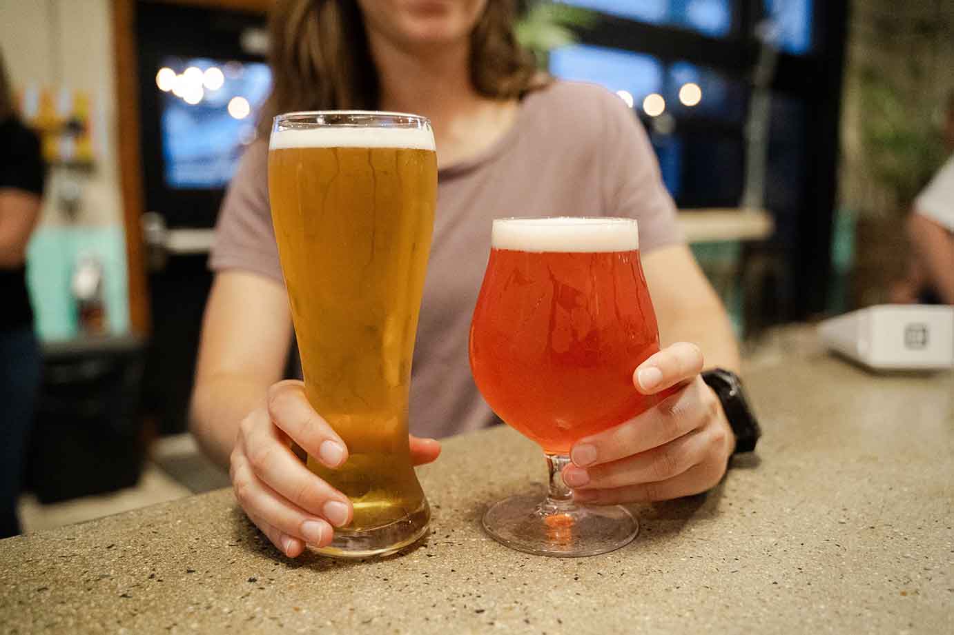 Hands holding two different types of craft beer