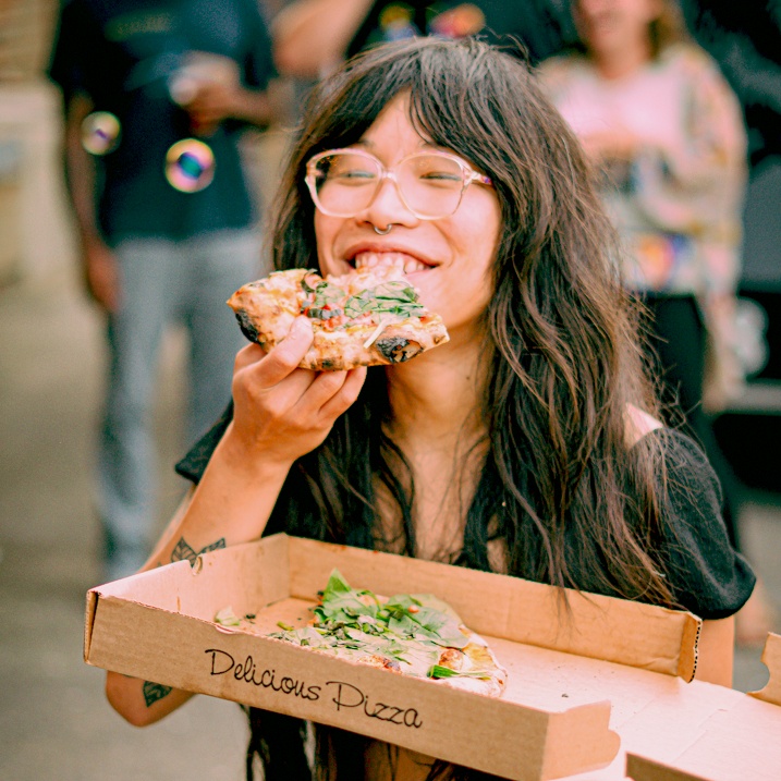 A girl enjoying a pizza slice