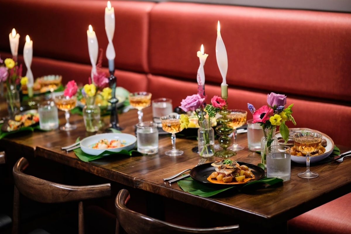 a table with plates of food and flowers on it