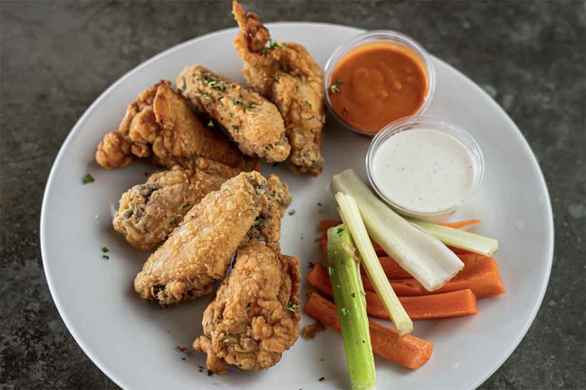 Fried chicken wings, wit celery, carrots, and dip