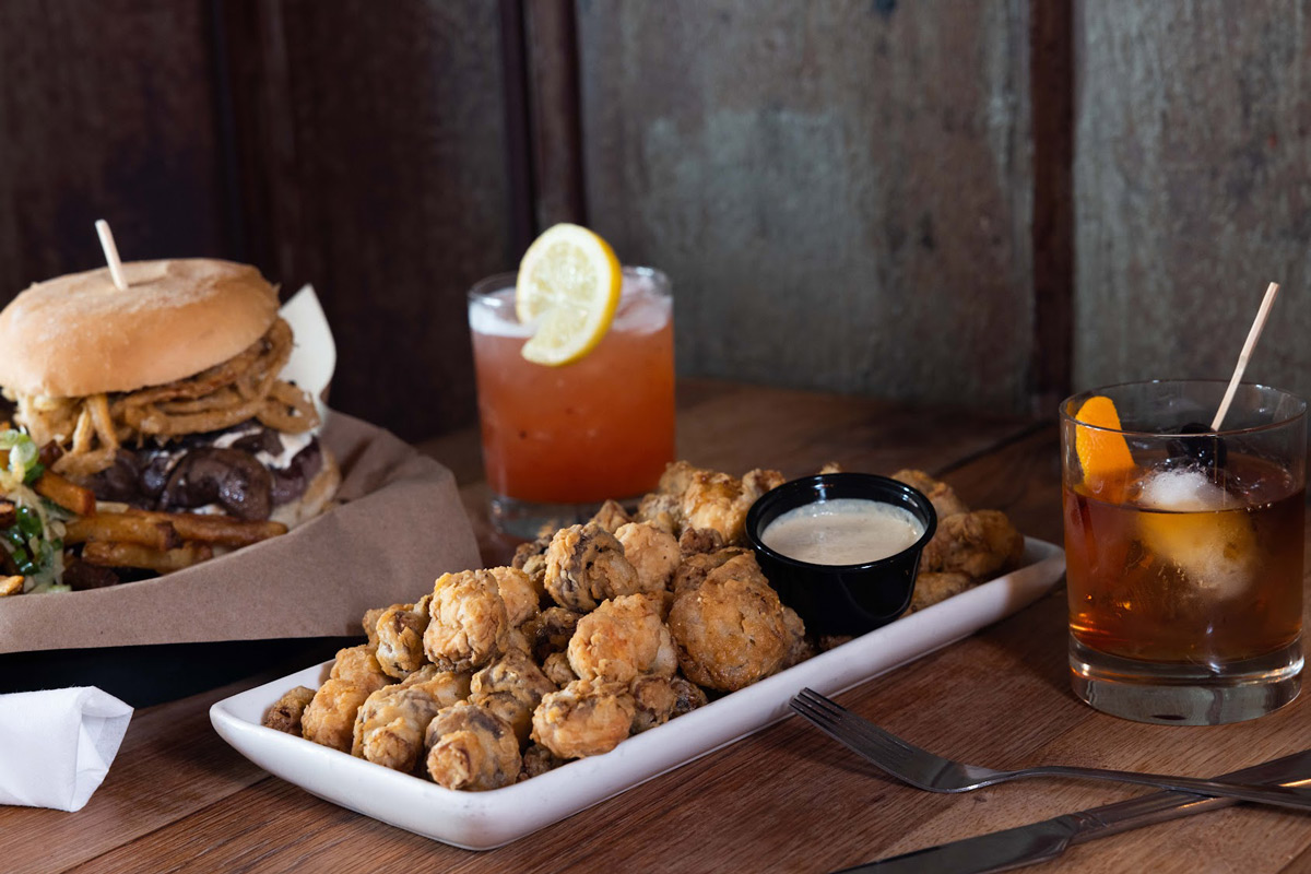 Fried mushrooms with dip, old fashioned cocktails and a burger on the side