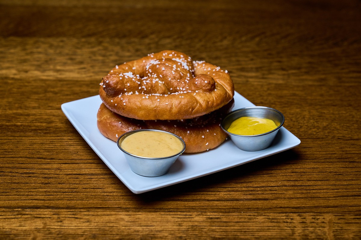 A stacked pair of large, warm, soft pretzels with coarse salt on top