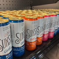 A row of cans of sunstory on a shelf