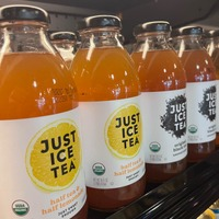 A row of bottles of just ice tea sitting on a shelf