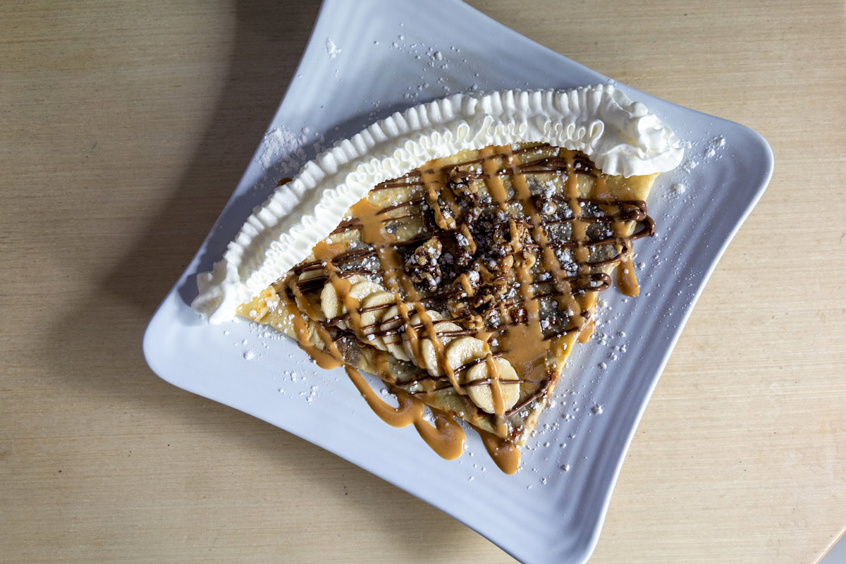 Crepe with bananas, peanuts, and whipped cream