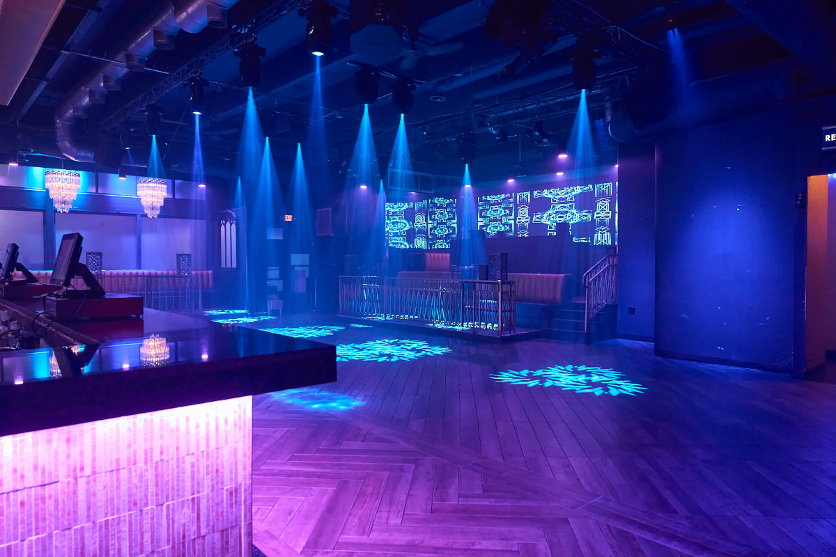 A nightclub with blue lights and a wooden floor