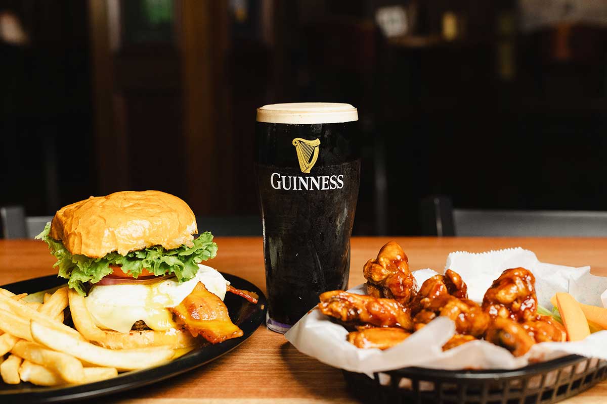 Cheeseburger and fries, chicken wings, and Guinness beer