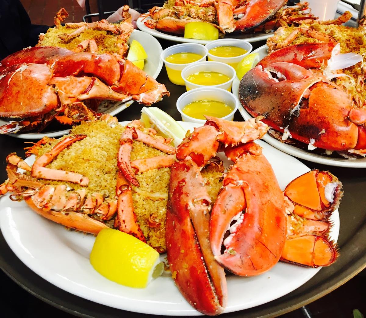 A plate of lobsters with lemon wedges on it.