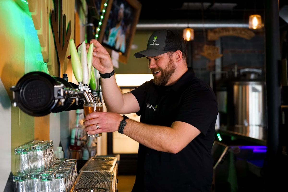 A bartender pouring a draft beer from tap