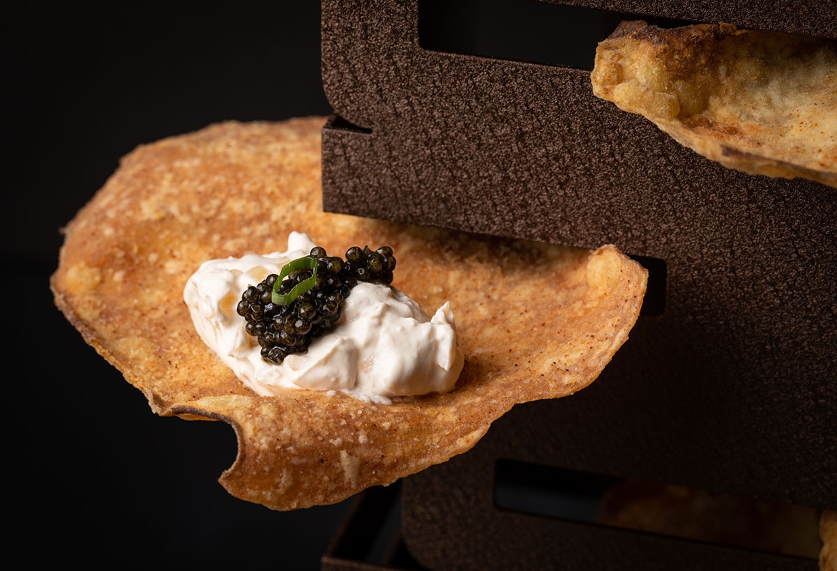 A plate of fried bread with caviar and whipped cream