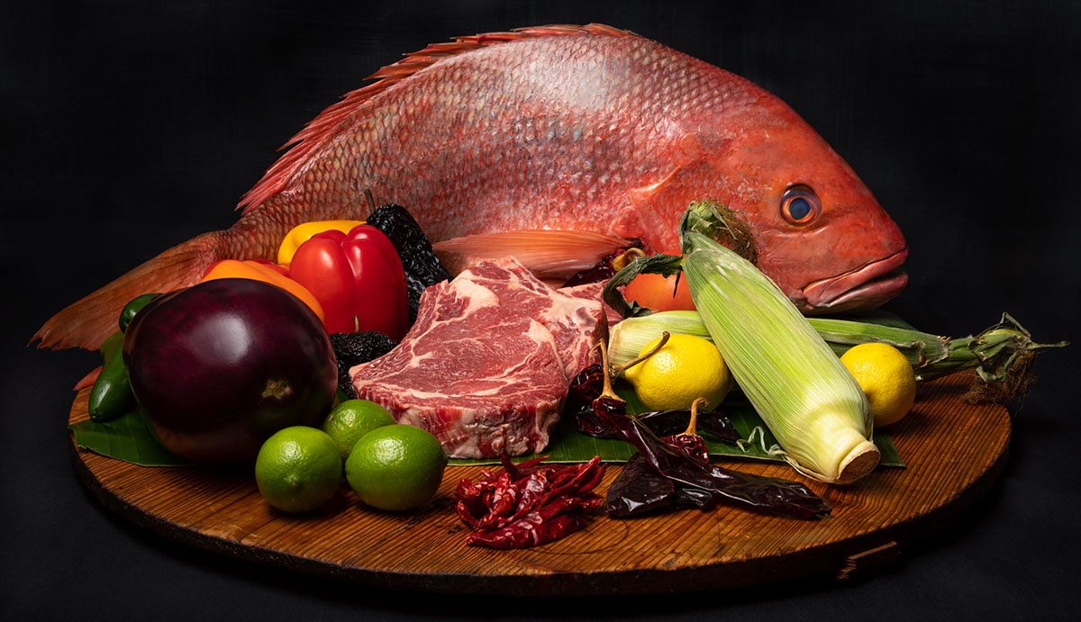 Fish, meat and vegetables on a wooden board