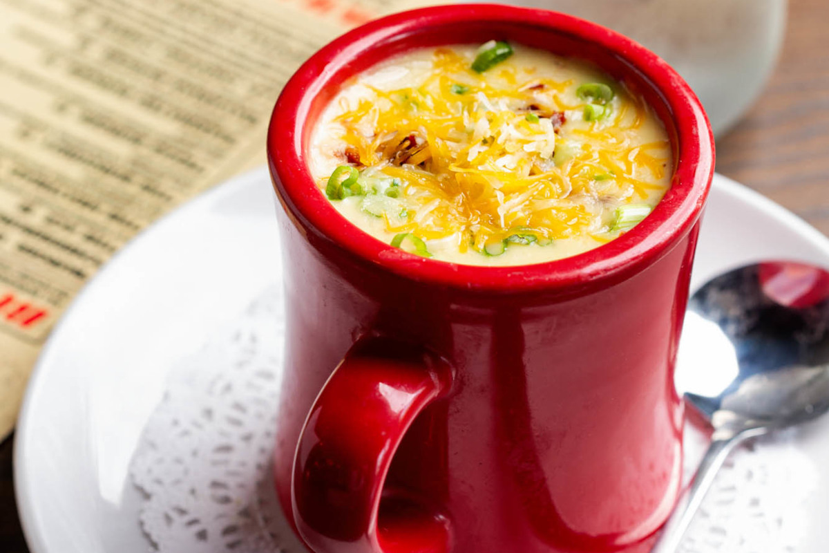 A red mug with a soup in it.