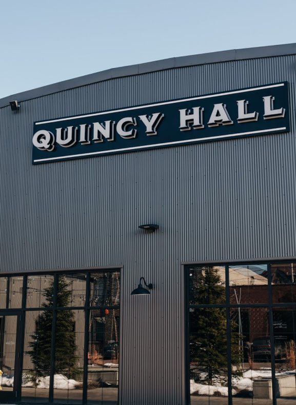 Exterior of quincy hall with large signage on an industrial-style building facade.