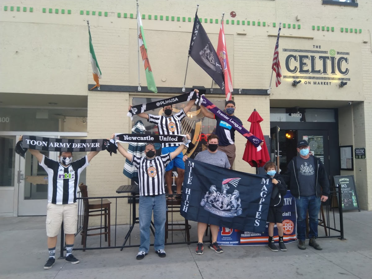 Customers posing with sports themed scarves and flags