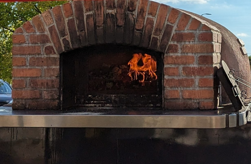 a brick oven with fire coming out of it
          n